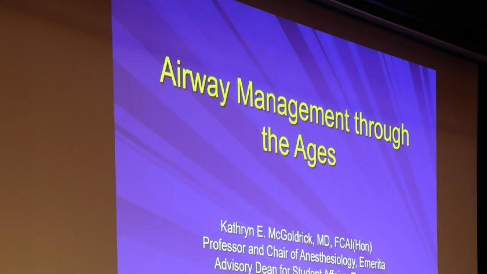 Woman presents her lecture to guests in auditorium.