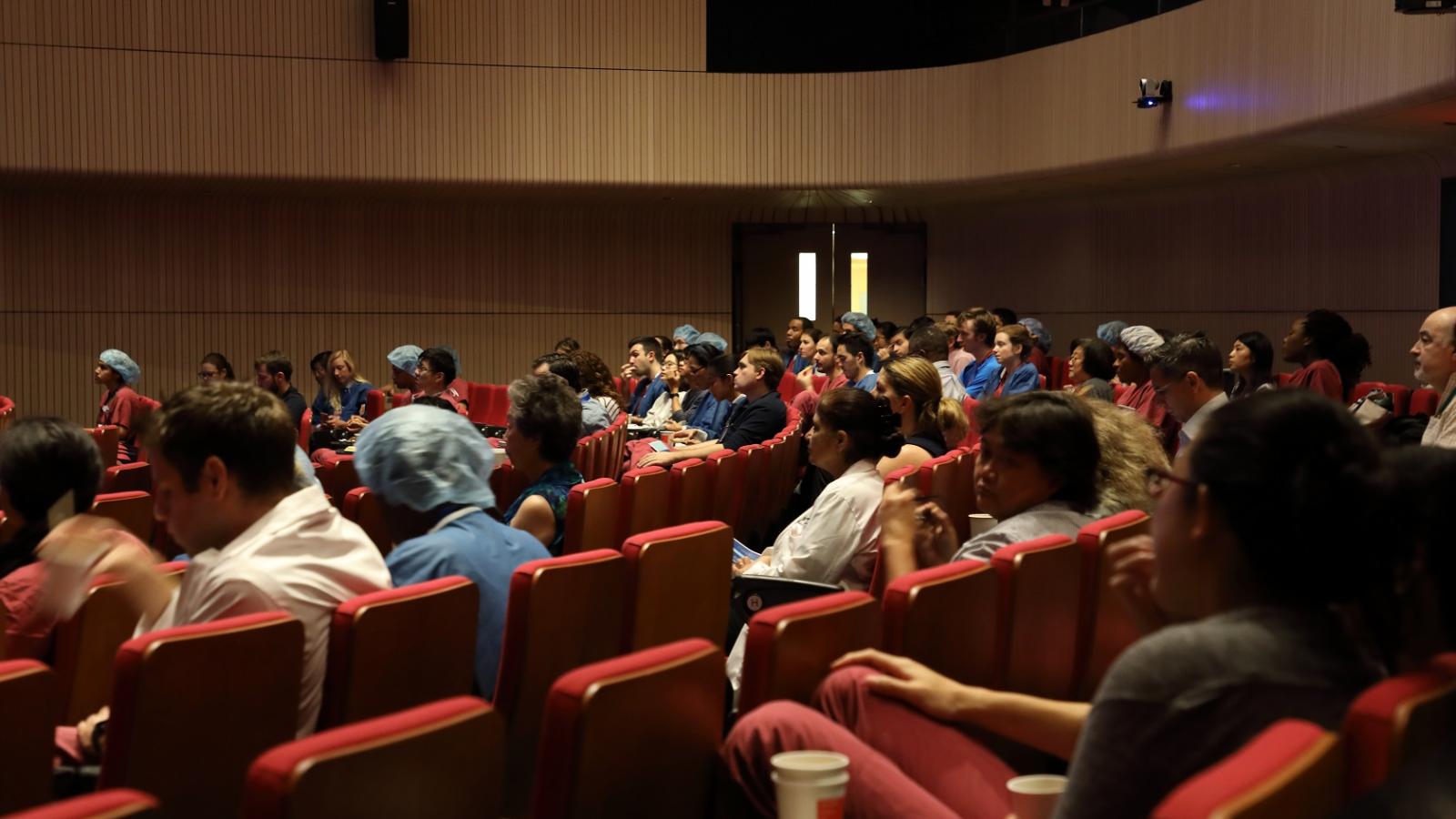 Auditorium filled with people listening to lecture