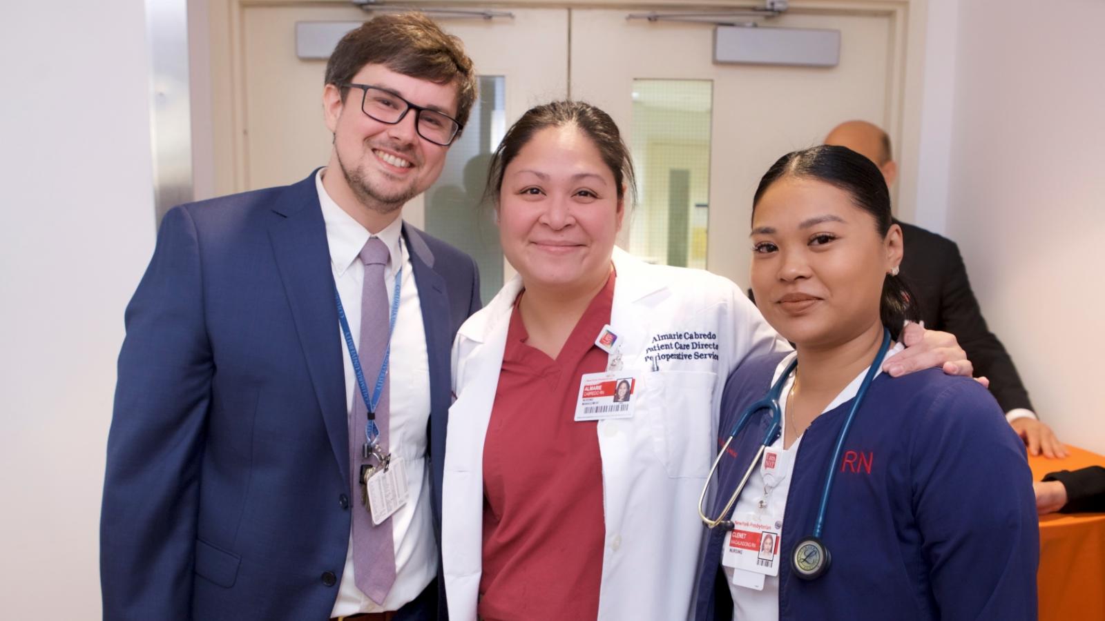 3 people pose for a photograph