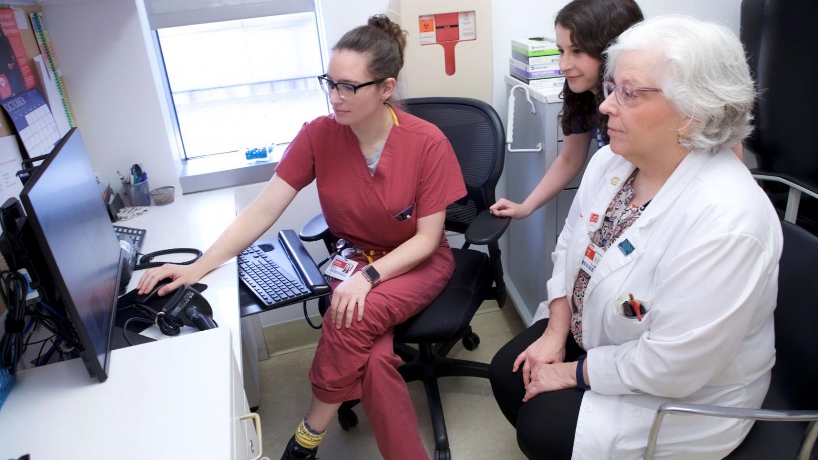3 women look at a computer