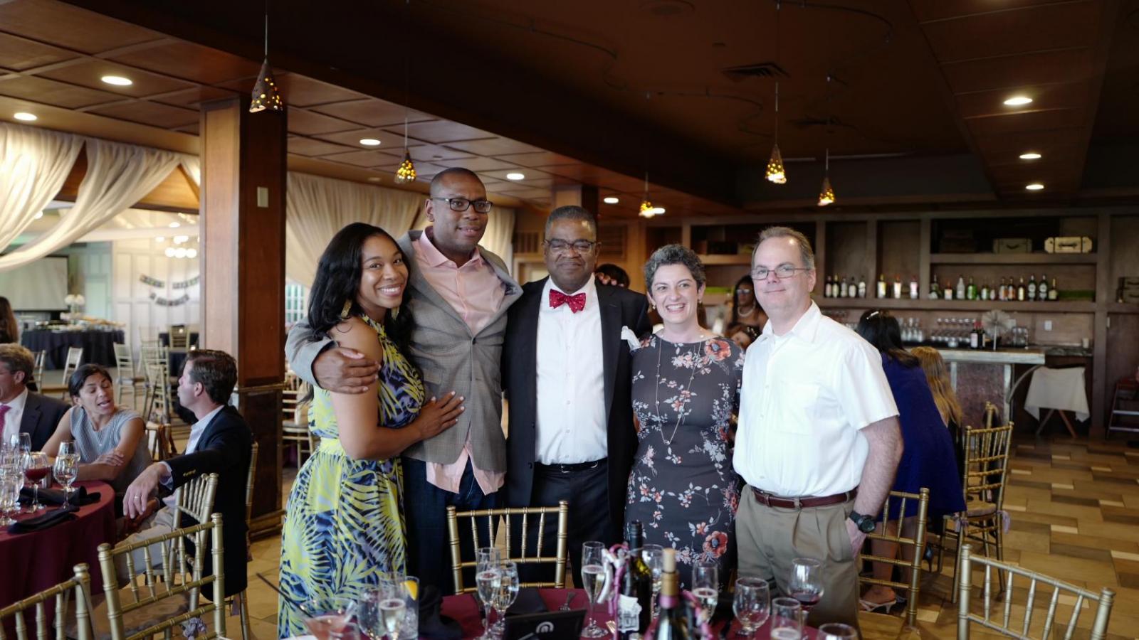 Smiling people standing around table