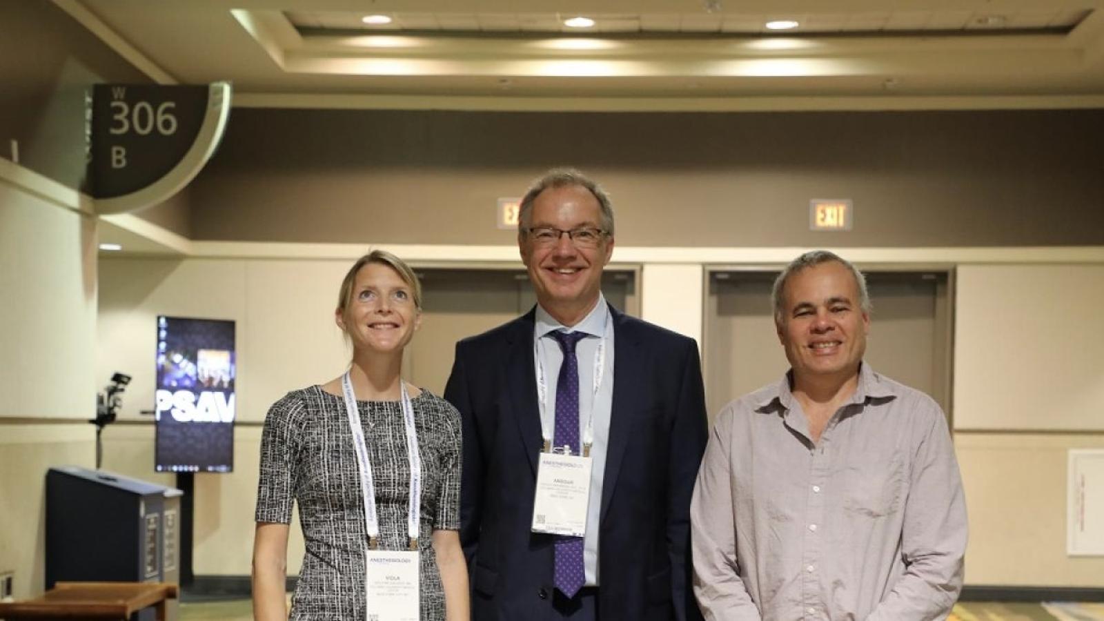 Two men and one woman in professional clothing and wearing conference nametags