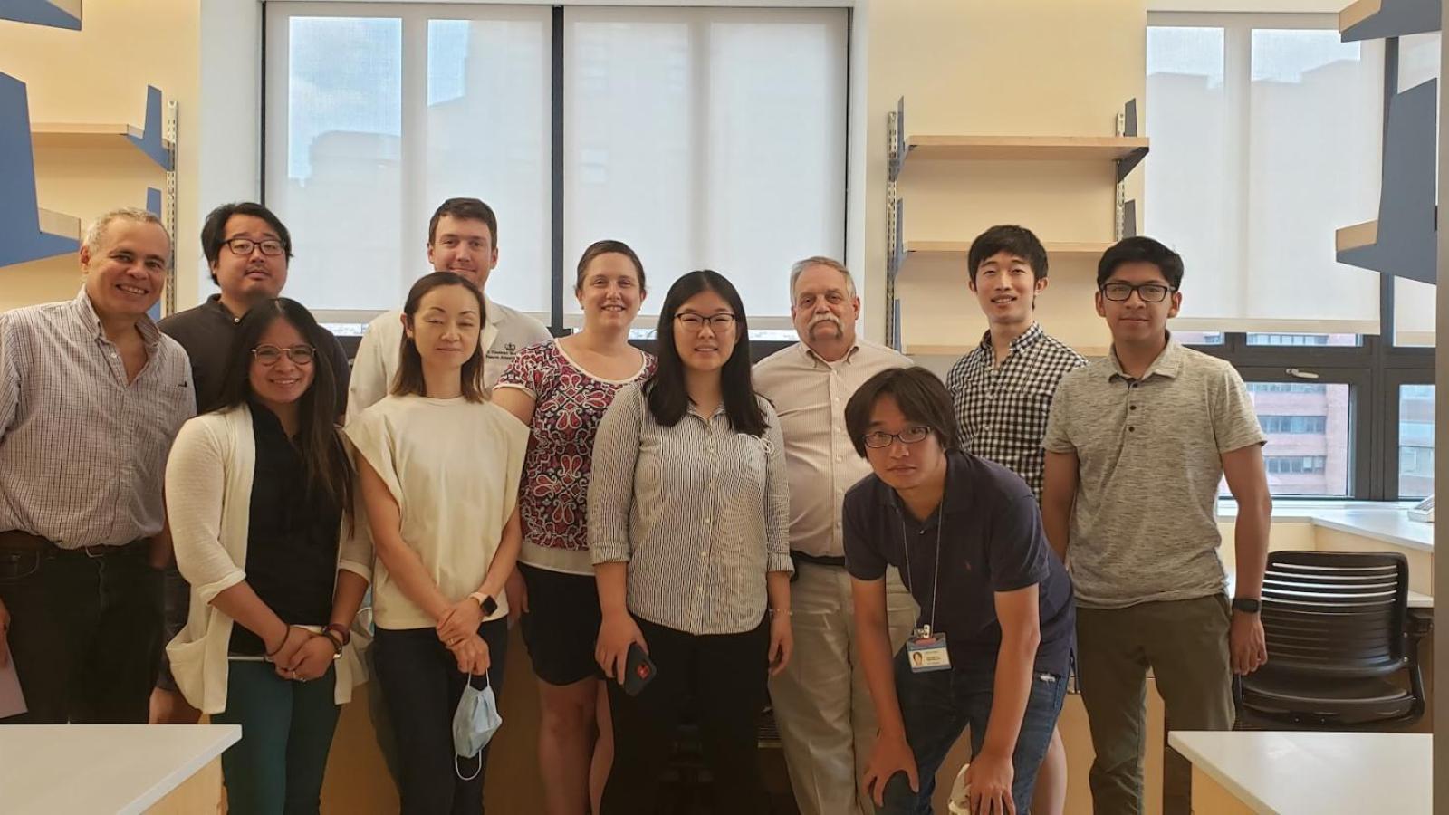 Group of several people in a research lab, windows at rear