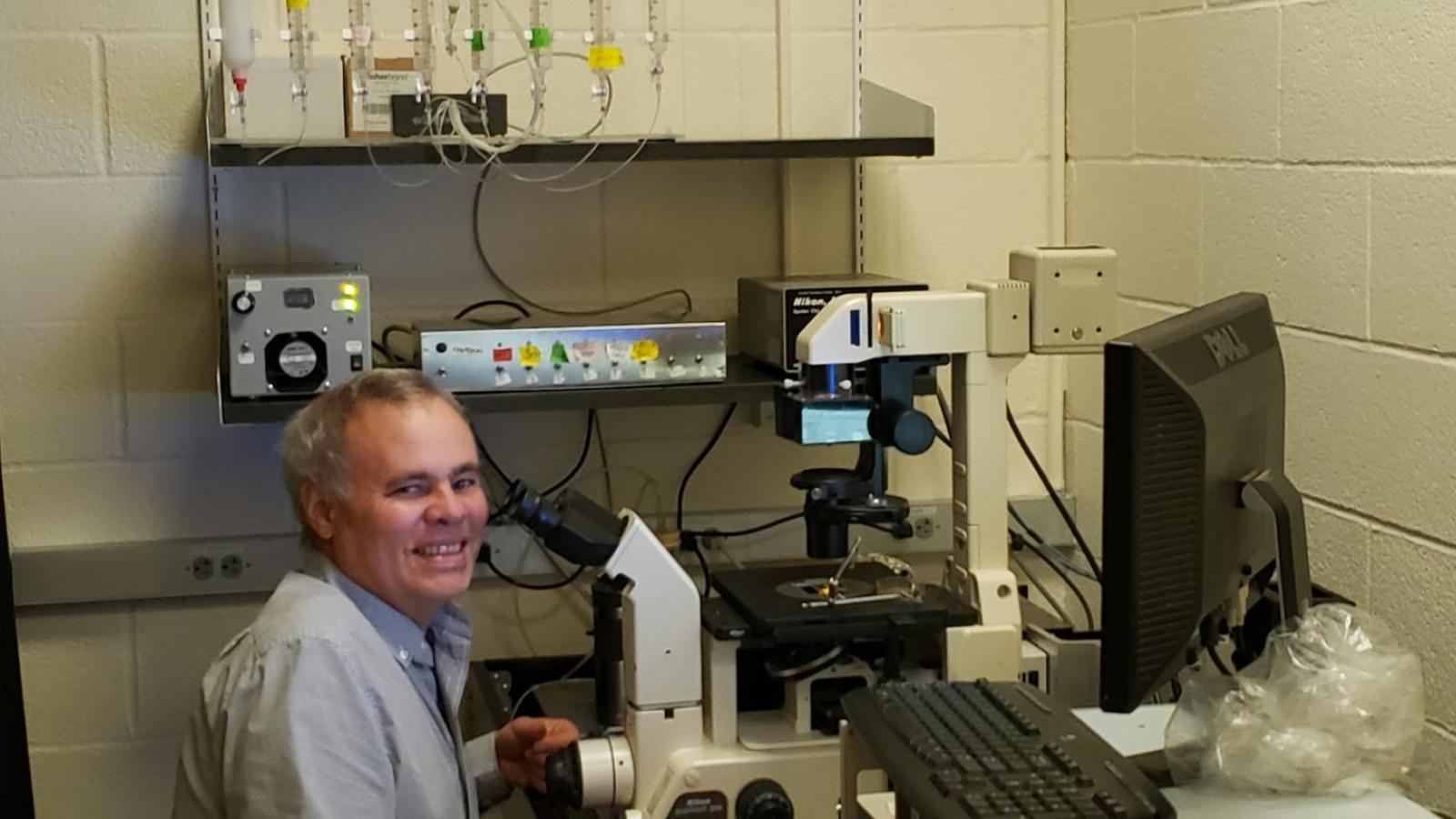 Man at microscope in lab