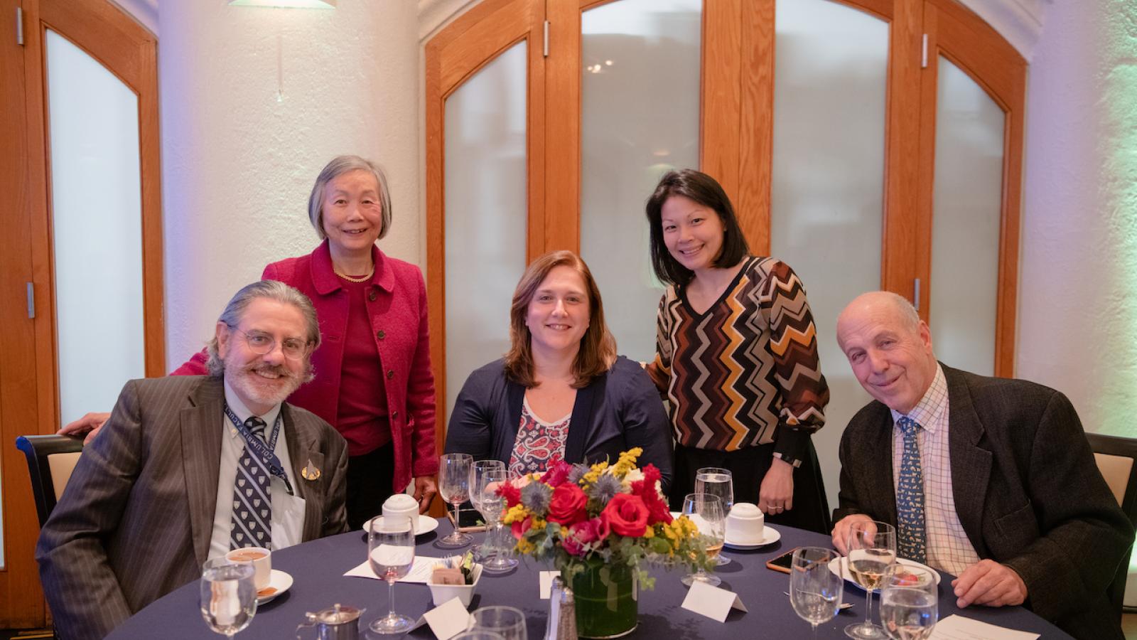Group at dinner table pose for photo
