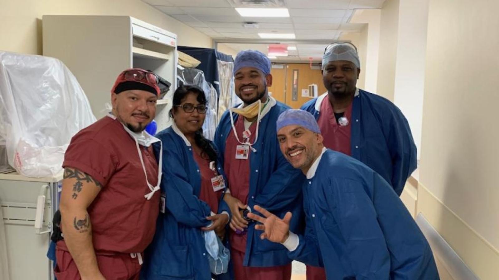 Five techs, smiling in hallway