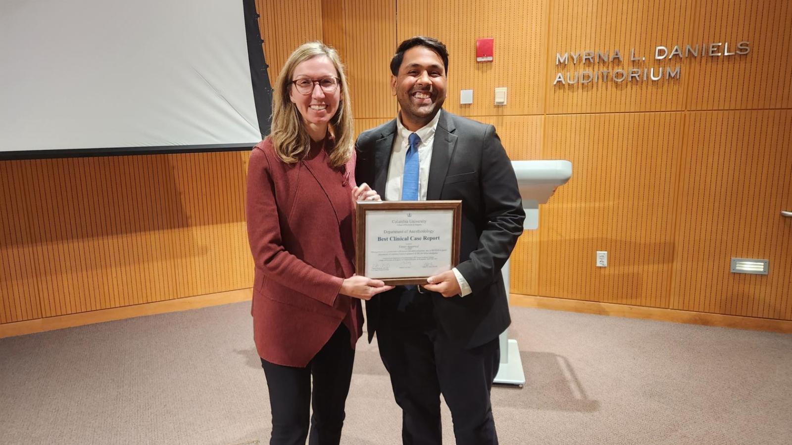Woman presenting an award to male resident