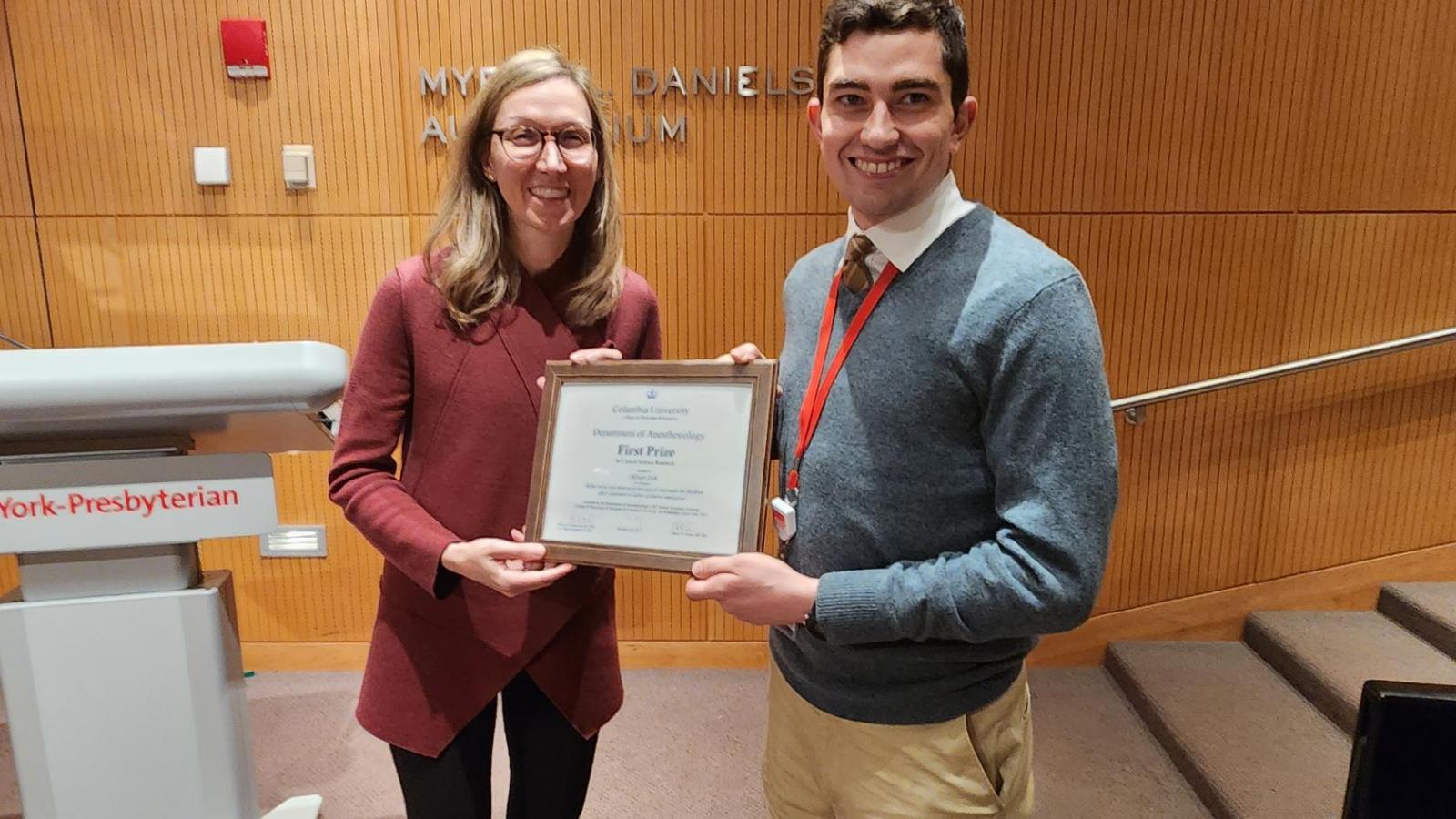Woman presenting an award to male resident