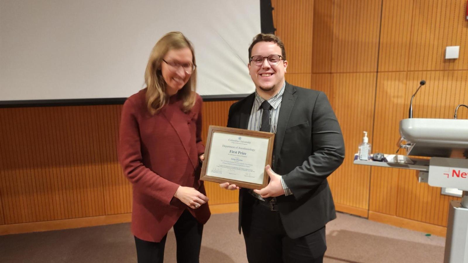 Woman presenting an award to male resident