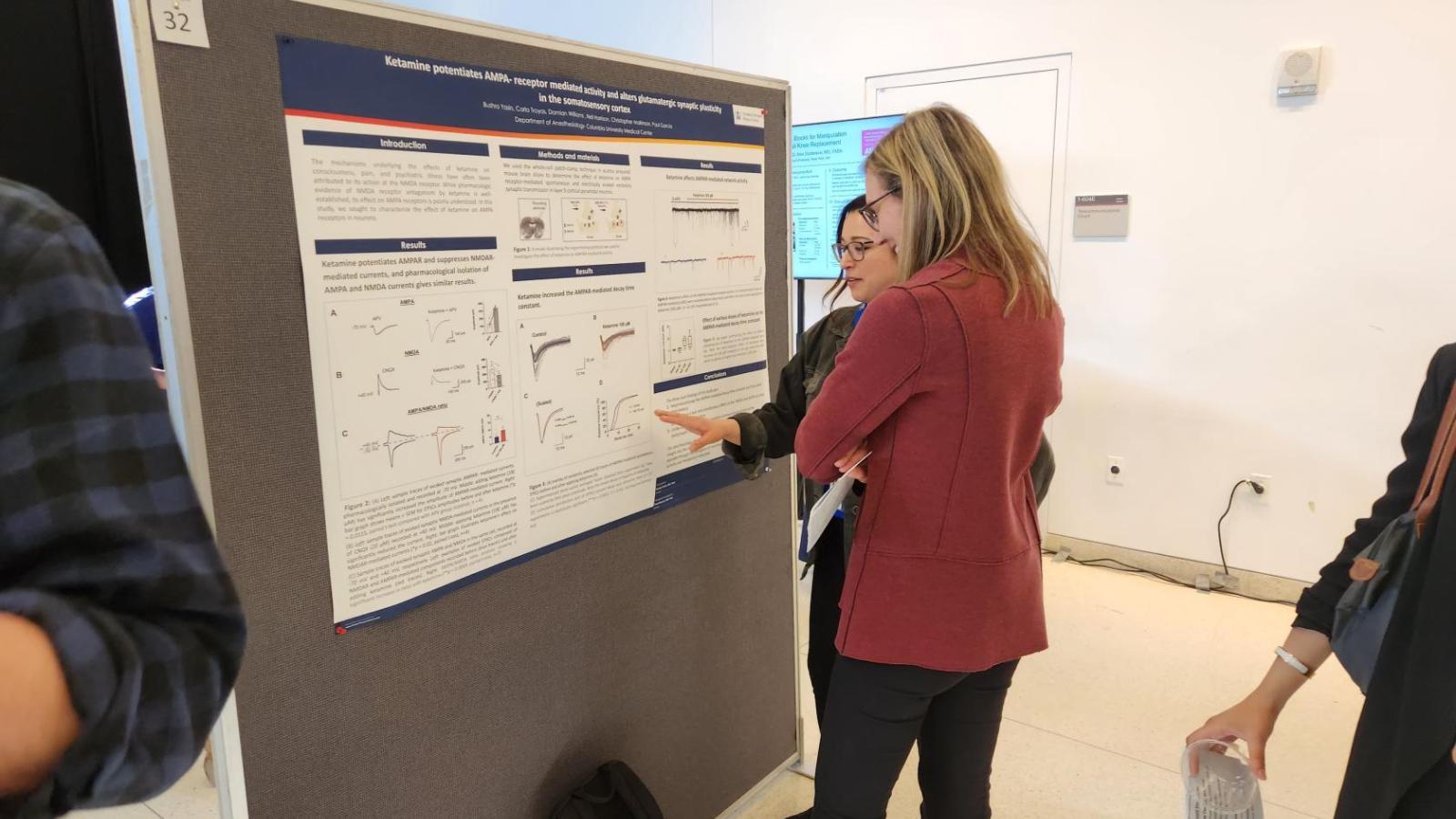 Two women standing in front of scientific poster