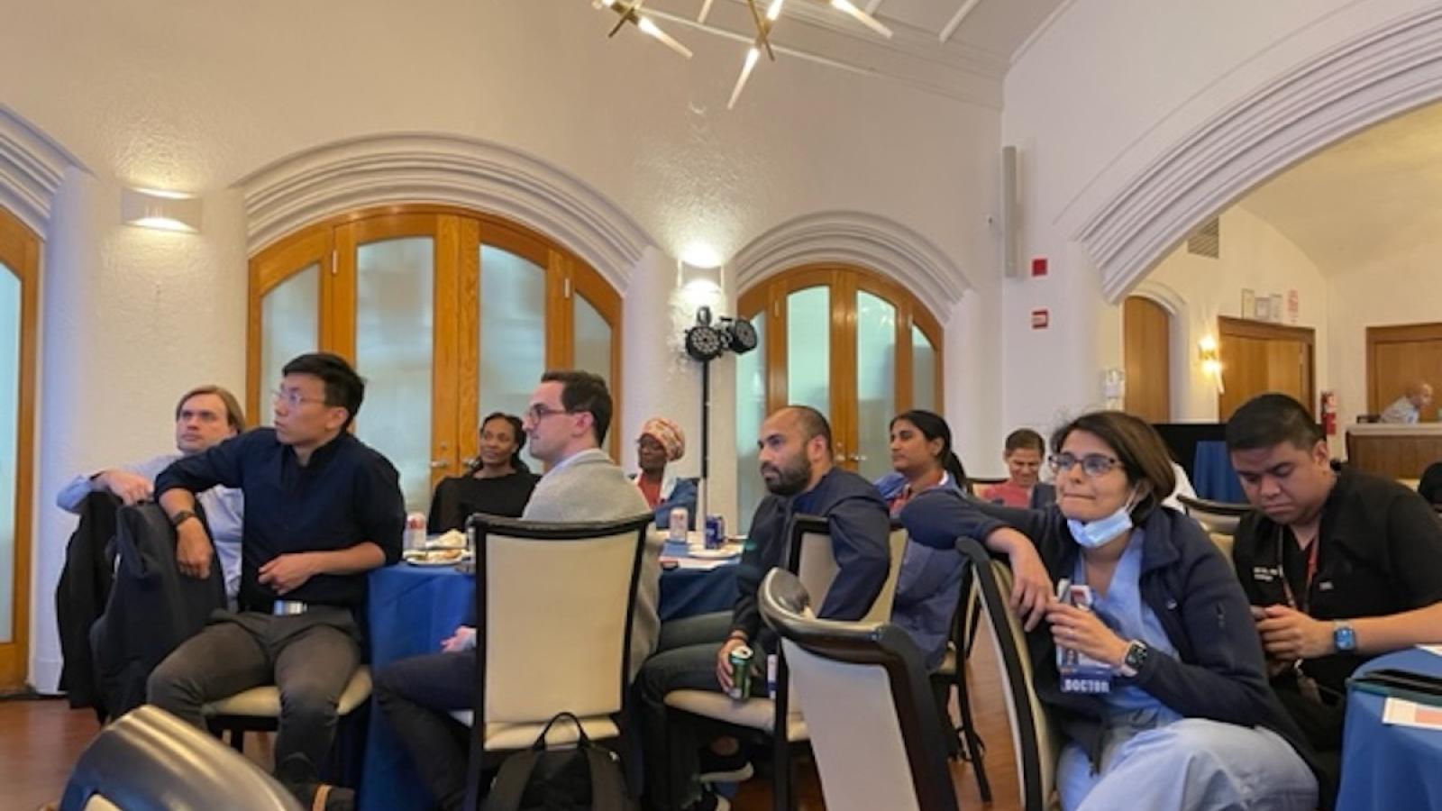 Groups at several tables listening to a speaker
