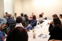 A group of people listening to a woman.