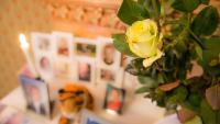 A memorial table with pictures and some flowers in the foreground